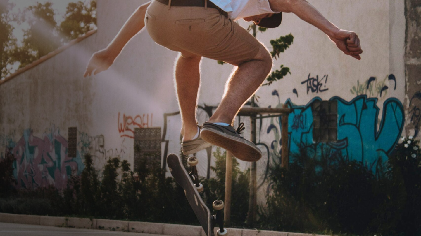 Mann macht einen Trick auf einem Skateboard