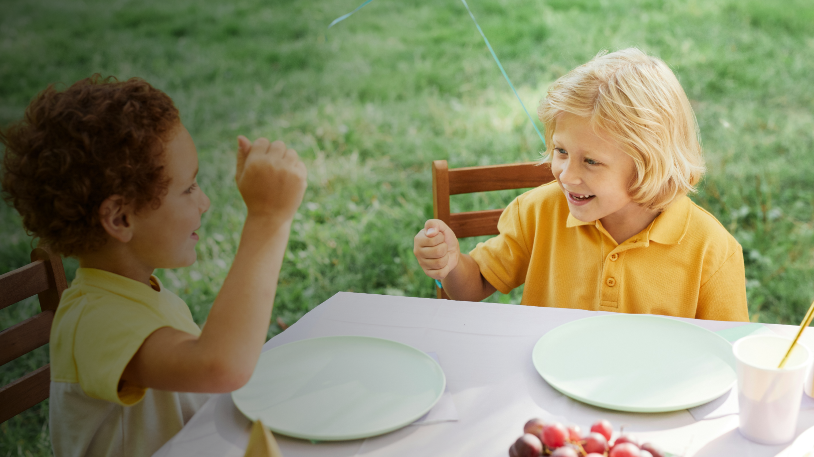 Kleinkinder sitzten strahlend am Tisch