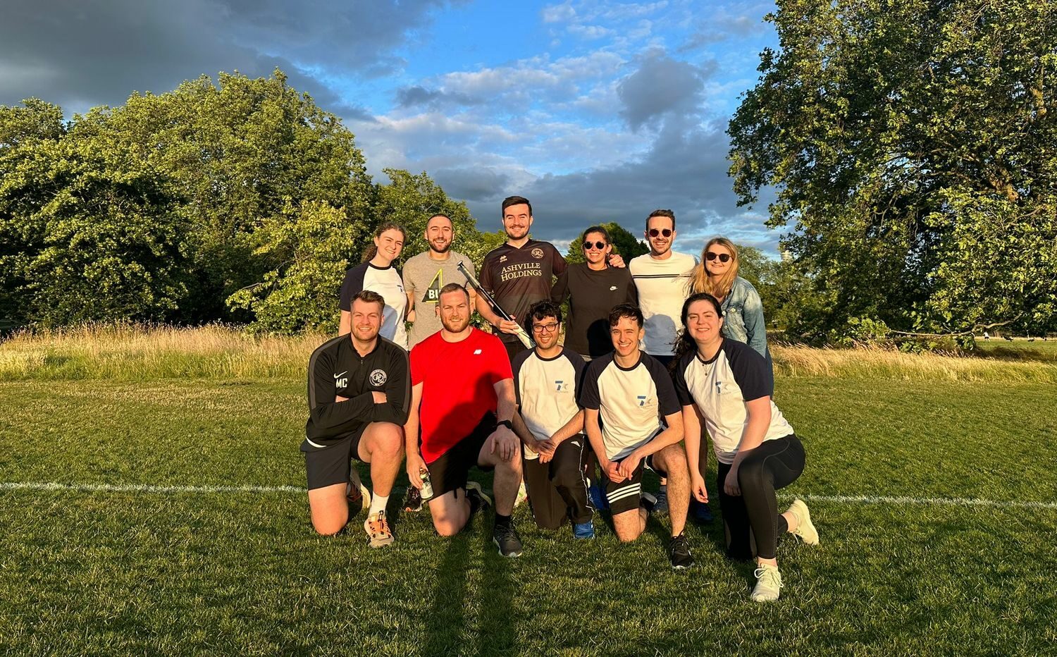 Eine Gruppe von Menschen posiert für ein Foto auf einem Fußballfeld.