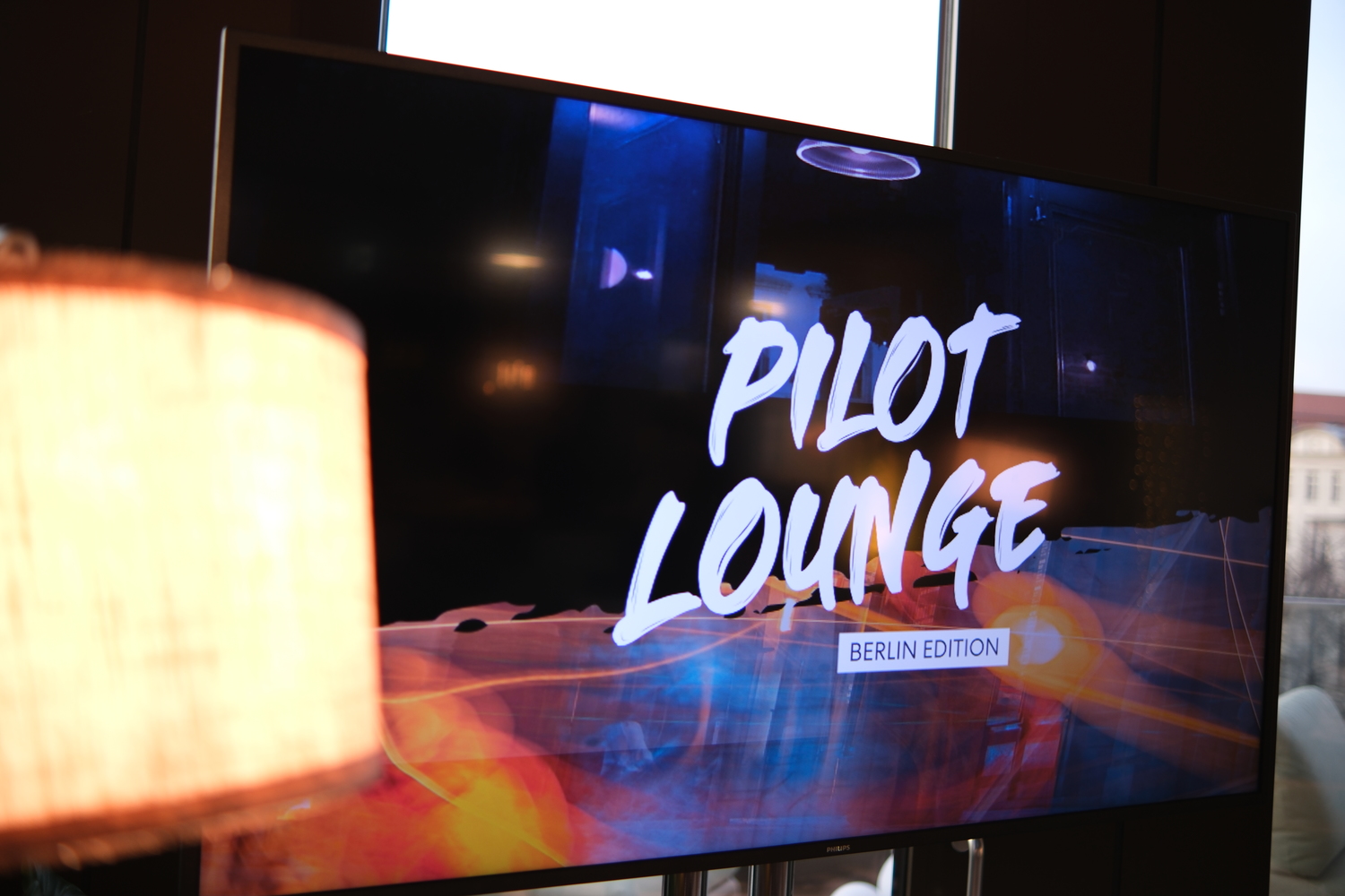 Fernseher mit dem Banner von pilot Lounge - Berlin Edition.