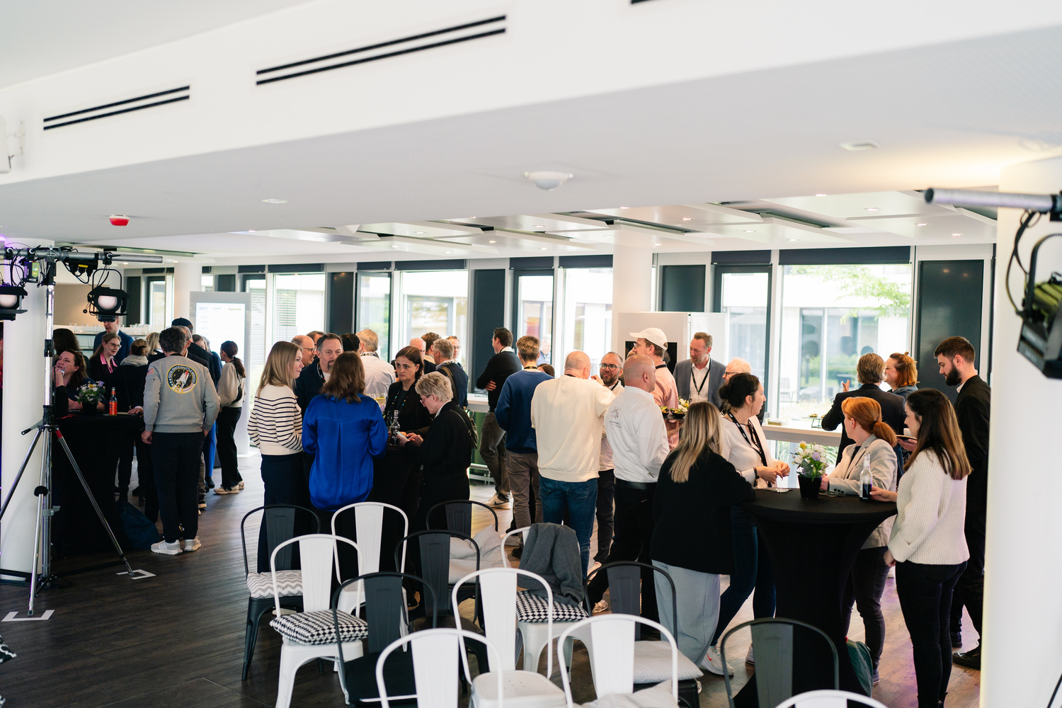 Eine Menschenmenge bei einem Networking-Event in einem modernen Veranstaltungsraum.