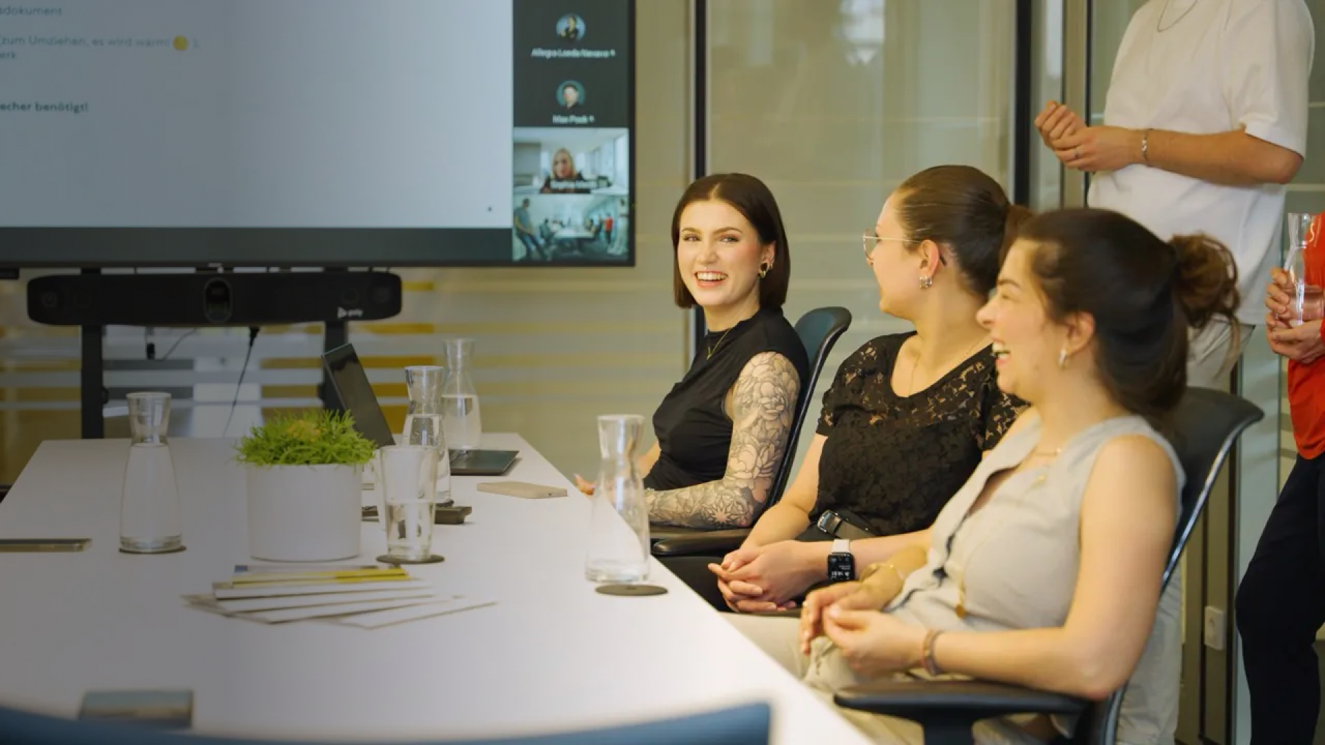 3 Mitarbeiterinnen von pilot sitzen an einem Konferenztisch und lachen