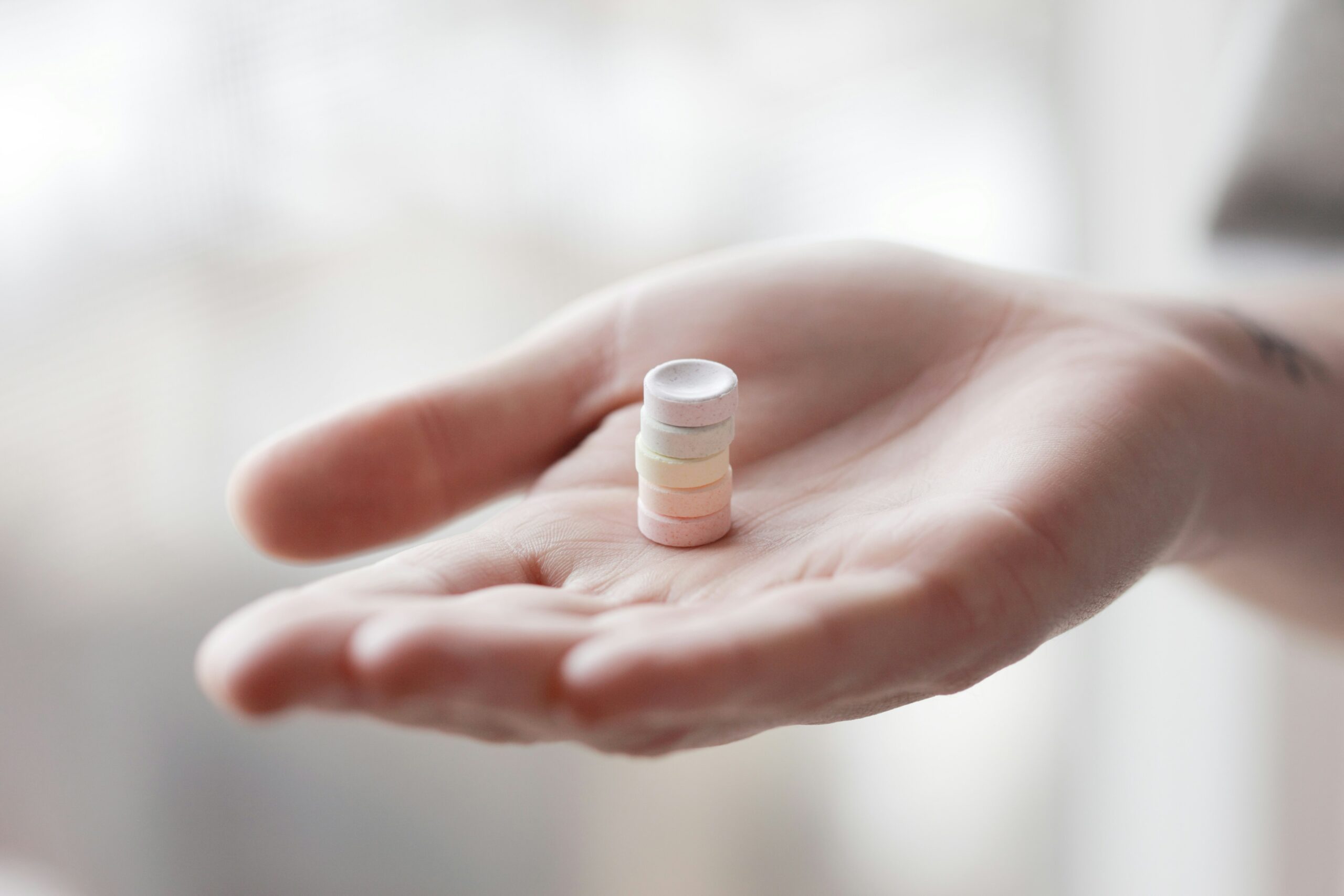 Ein Stapel Tabletten auf einer Frauenhand